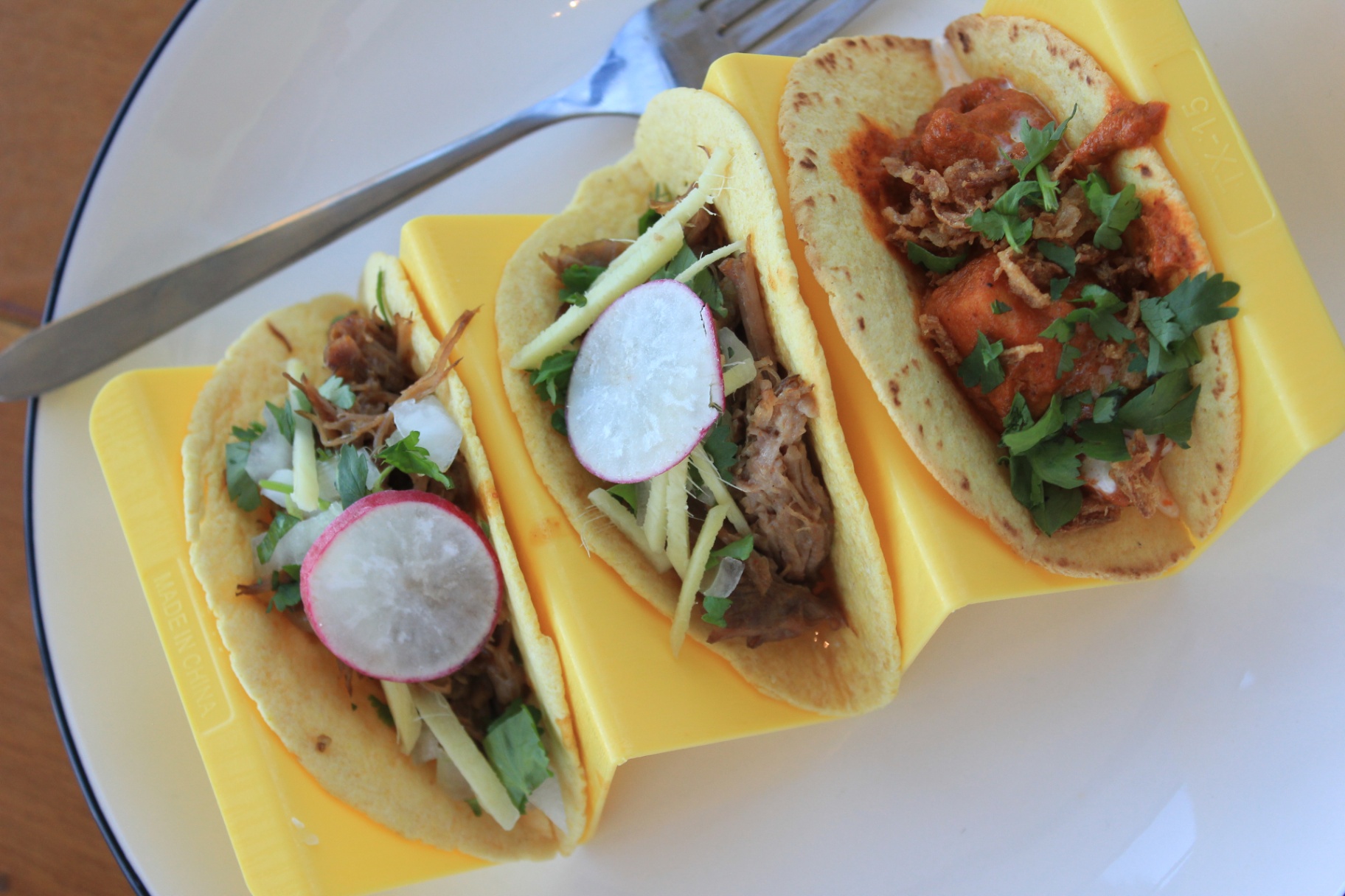 Yellow taco holders plated with fresh garnishes